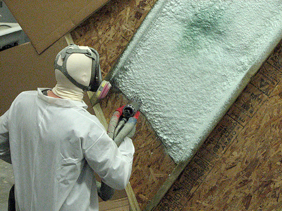 Applying spray foam insulation.